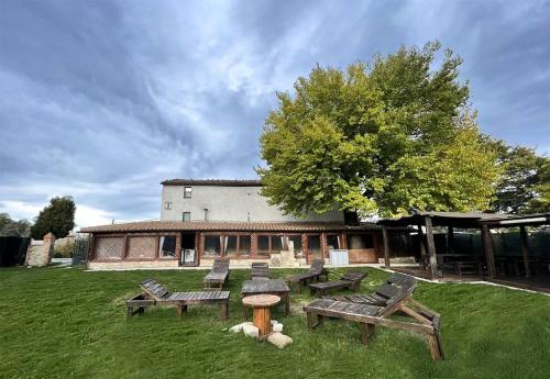 a group of picnic tables in front of a building at Casale Viozzi - Casa Vacanze con piscina nelle Marche in Montefalcone Appennino