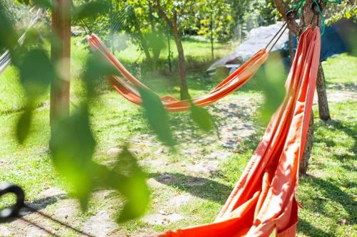 a couple of red hammocks in a yard at Casale Viozzi - Casa Vacanze con piscina nelle Marche in Montefalcone Appennino