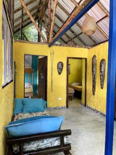 a room with a couch and a yellow wall at Ecolodge el Arca Bahia Solano in Bahía Solano