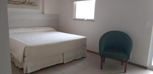 a bedroom with a bed and a blue chair at Mont blanc Porto marina in Mangaratiba