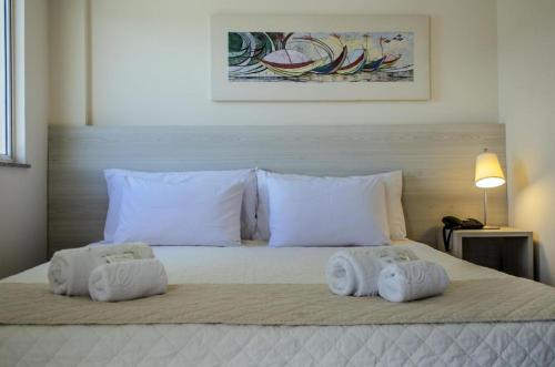 1 dormitorio con 1 cama con toallas en Mont blanc Porto marina, en Mangaratiba
