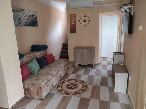 salon z kanapą i podłogą wyłożoną kafelkami w obiekcie Tavasz apartman w mieście Balatonfenyves