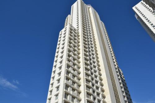 a tall white building against a blue sky at Skyview City Apartment in Skopje