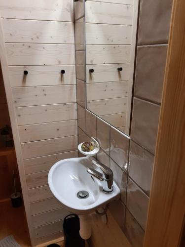 Baño con lavabo blanco y paredes de madera en Bratrouchovský trpaslík, en Jablonec nad Jizerou