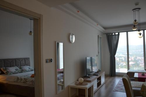 a bedroom with a bed and a tv and a mirror at Skyview City Apartment in Skopje