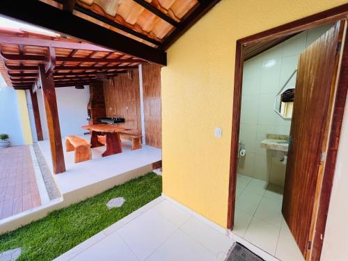Casa de Temporada - Praia Miaí de Baixo - Coruripe في كوروريبي: غرفة مع طاولة وباب زجاجي