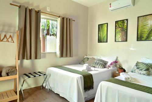 1 dormitorio con 2 camas y ventana en CASA CHARME DO CERRADO, en Pirenópolis