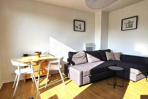 un salon avec un canapé et une table dans l'établissement La terrasse de Clovis, à Reims