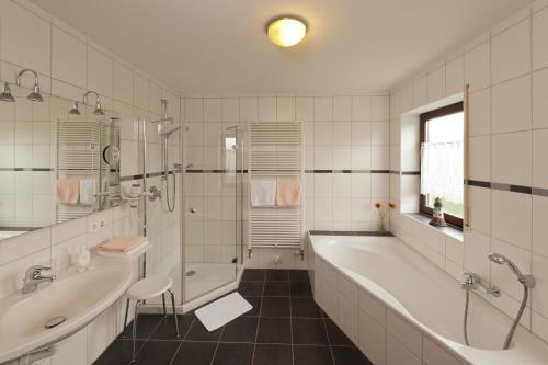 een badkamer met een bad, een douche en een wastafel bij Sindersdorfer Hof in Hilpoltstein