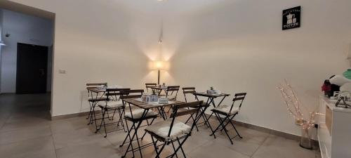una habitación con mesas y sillas con una luz en la pared en RUMA GUESTHOUSE, en Nápoles