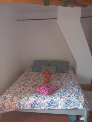 Una cama con un florero encima. en Les Jardins de l'Imaginaire, en Monségur
