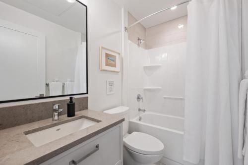 Baño blanco con lavabo y aseo en Beachfront Luxury Suite #18 at THE BEACH HOUSE, en Campbell River