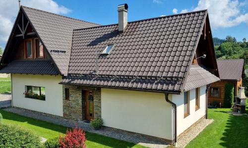 a house with a metal roof at Ubytovanie Lenka in Osturňa