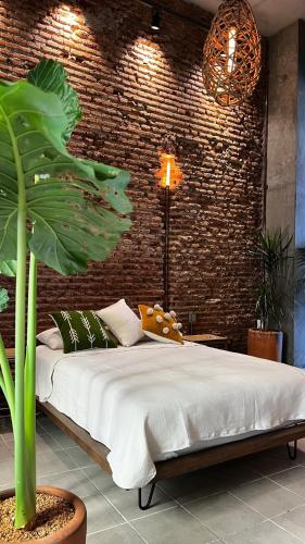 a bedroom with a bed and a brick wall at CASA PATO in Oaxaca City