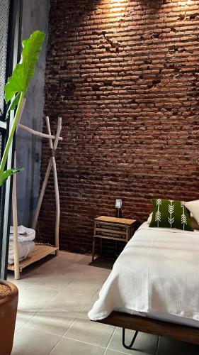 a bedroom with a brick wall and a bed at CASA PATO in Oaxaca City
