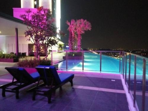 ein Gebäude mit Swimmingpool in der Nacht in der Unterkunft i-Duplex 1M2R2B Condo - LED Garden, Fun Fair, Waterpark, Wax Museum, Mall & More! in Shah Alam