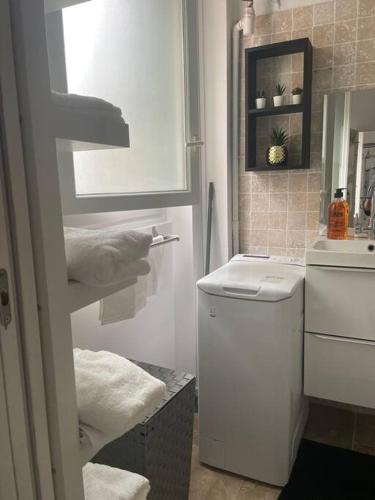 a bathroom with a toilet and a sink with towels at Cosy Apartment In paris in Saint-Ouen