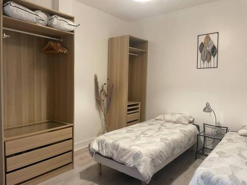 une chambre avec un lit et une commode dans l'établissement Cosy Apartment In paris, à Saint-Ouen