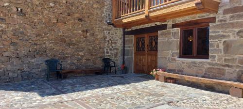 a stone building with a wooden door and a bench at Casa Rural Pembes in Pembes