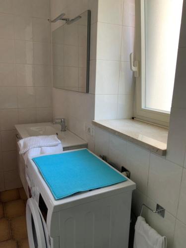 a white bathroom with a sink and a mirror at Al numero 5 in Francavilla di Sicilia