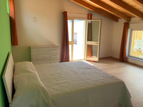 a bedroom with a bed and a dresser and a window at Al numero 5 in Francavilla di Sicilia