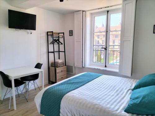 une chambre avec un lit, un bureau et une fenêtre dans l'établissement MUTUM - Studios 2 personnes ou duplex 5 personnes , idéalement placés à 100m de la plage, à Dieppe