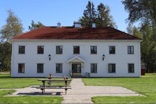 un gran edificio blanco con una mesa de picnic delante de él en Studio apt close to Airport, en Garder