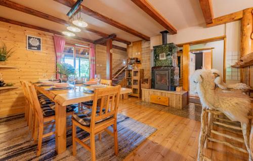 a dining room with a table and a room with animals on the chairs at Holiday Home Lika Mazin in Gračac
