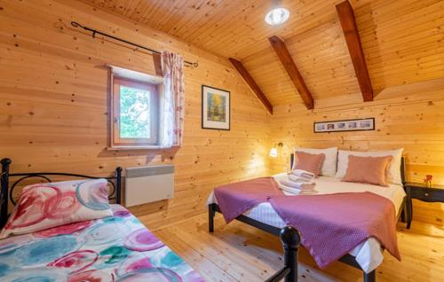a bedroom with two beds in a log cabin at Lika holiday home Mazini in Gračac