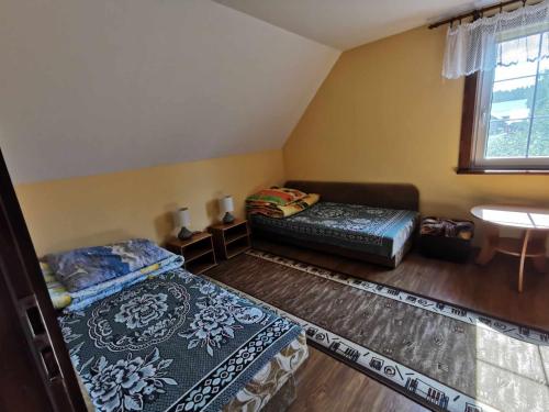 Habitación con 2 camas, sofá y lavamanos en U Romaniuków en Werstok