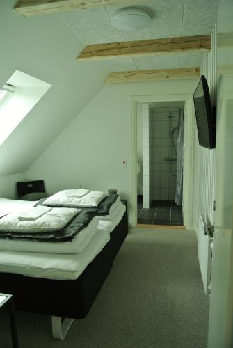 a bedroom with a large bed and a bathroom at Kærskovgård ferielejligheder in Faxe