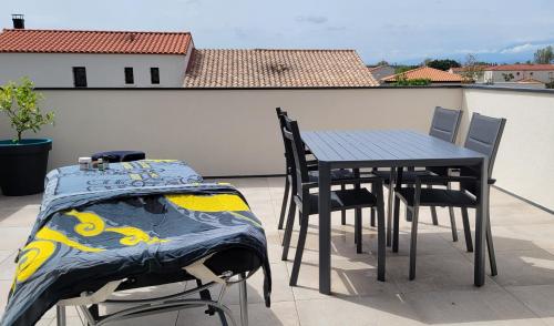 een tafel en stoelen op een balkon met een tafel en een bed bij Studio vue montagne in Rivesaltes