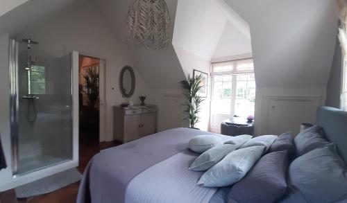 um quarto com uma cama com almofadas e um chuveiro em Huize Koempoelan em Naarden