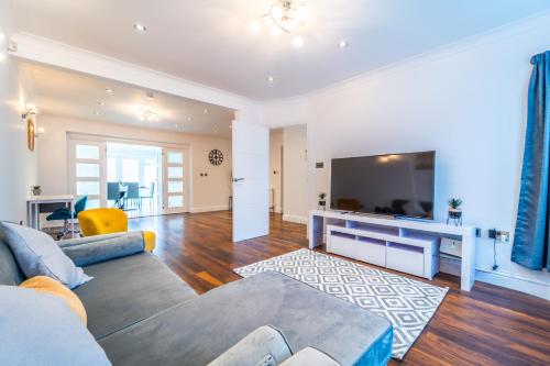 a living room with a couch and a flat screen tv at Modern Spacious 4 Bed Hayes Home with Free Parking in Hayes