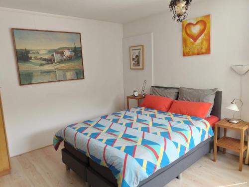 1 dormitorio con 1 cama y una pintura en la pared en Kop vd Hondsrug1 en Haren