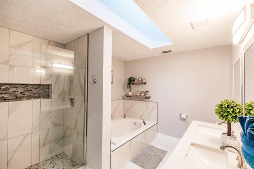 a bathroom with a shower and a tub and a sink at Beautiful Home in Naples with Huge Private Pool in Naples