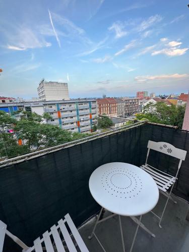 a white table and two chairs on a balcony at Moderne Wohnung mit 2 Balkonen, Self check-in, Parking in Graz