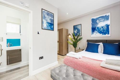 a bedroom with a large bed with blue pillows at Quality Spitalfields Accommodations in London