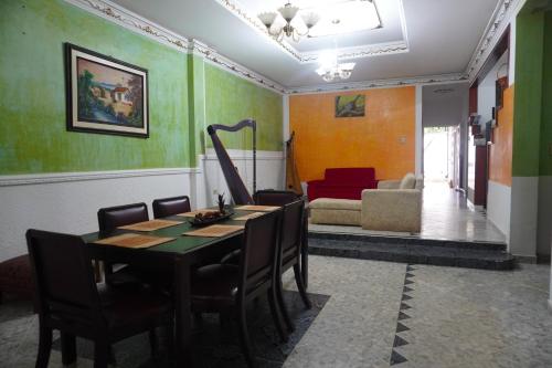 een eetkamer met een tafel en stoelen en een bank bij Hostal Castañeda in San José del Guaviare