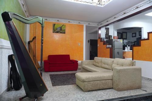 sala de estar con sofá y silla roja en Hostal Castañeda, en San José del Guaviare