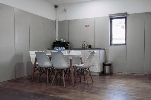 a dining room with a table and white chairs at Hostel Middle Point in Sardoal