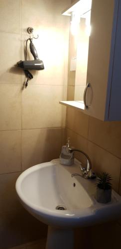 a bathroom with a sink with a light and a mirror at Vilaeti Estia in Agios Konstantinos