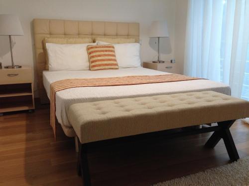 - une chambre avec un grand lit et un banc dans l'établissement Quinta da Martinela Ferreira Do Zêzere, à Ferreira do Zêzere