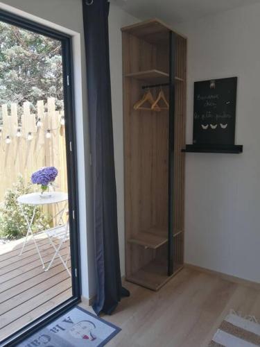 une chambre avec une porte coulissante en verre et une table dans l'établissement Studio Les petites poules, à Saint-Lyphard