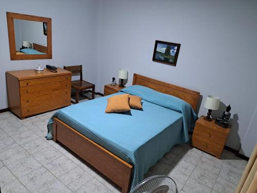 a bedroom with a blue bed and a mirror at Quarto amplo do apartamento no Palmarejo in Praia