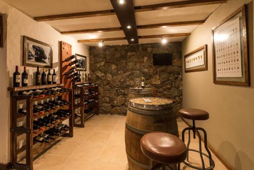 uma sala de degustação de vinhos com um barril e bancos em Posada Mawida em Maipú