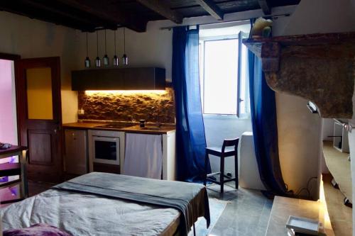 Cet appartement comprend une chambre avec un lit et une cuisine avec une fenêtre. dans l'établissement Favola sul lago, à Brissago
