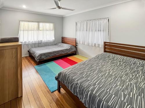 1 dormitorio con 2 camas y alfombra de arco iris en Baan Talay, en North Haven