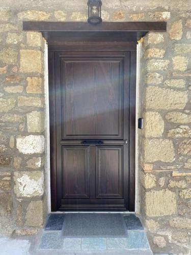 a large wooden door in a stone wall at Lithic Suites 1 in Kalabaka