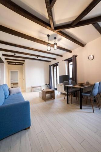 a living room with a blue couch and a table at Lithic Suites 1 in Kalabaka